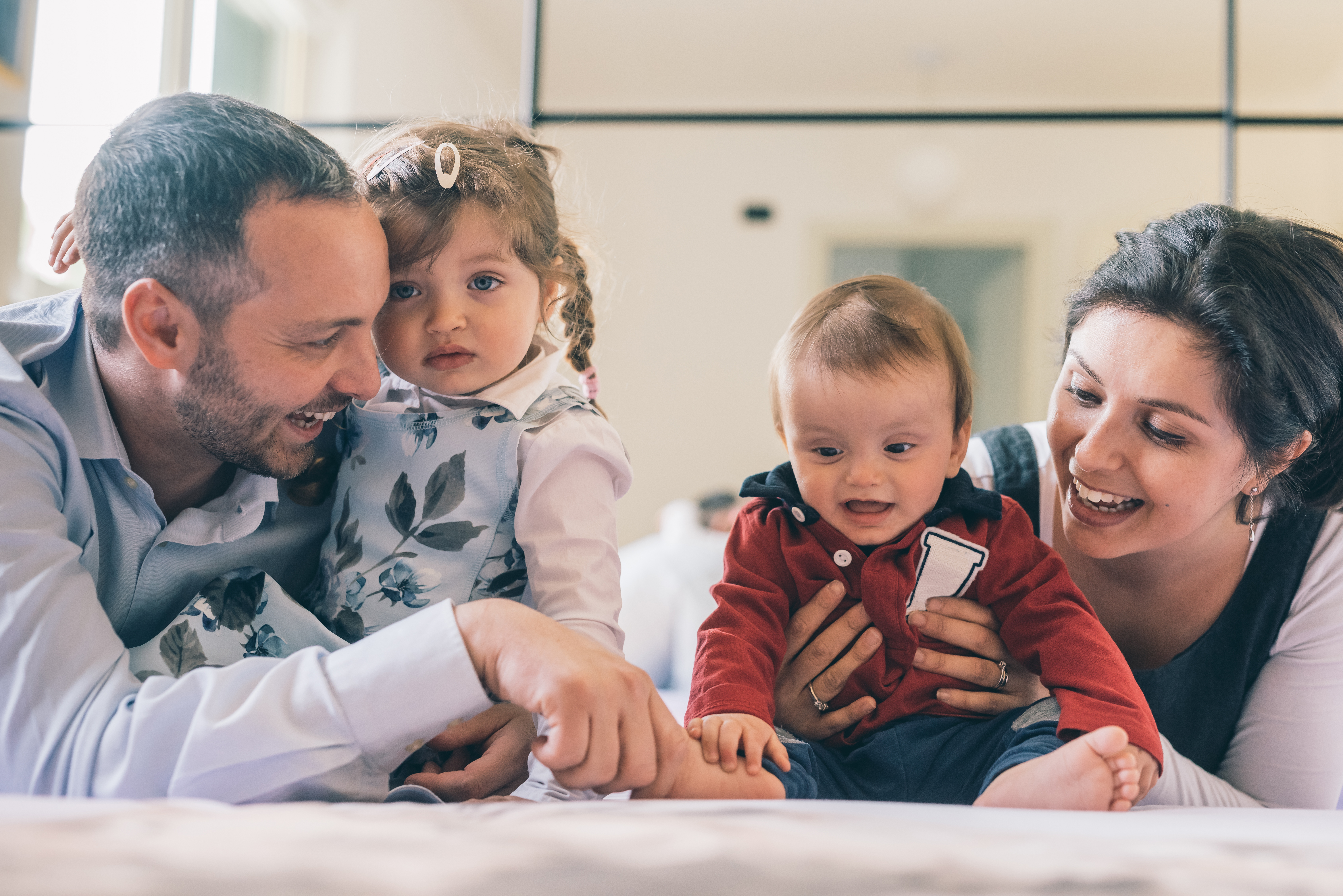 Happy family with two kids indoor at home playing together